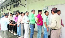 Secretariat employees wait for their turn to vote in Dehradun