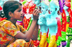 An artist gives final touches to the statue of Lord Krishna on the eve of Janamashtmi in Ludhiana