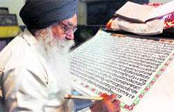 Gurmeet Singh (72) works on a handwritten version of Guru Granth Sahib at his home in Amritsar on Tuesday, the eve of the celebration of the 406th anniversary of the installation of Guru Granth Sahib in the Golden Temple. Gurmeet Singh, who began his work on May 7, 2004, completed it in six years and two months
