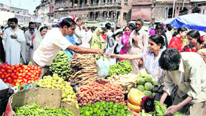 People buy vegetables in a market after the lifting of the curfew in Srinagar on Wednesday.