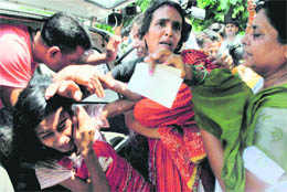 pain... anxiety...anger: Security personnel take away the wife of kidnapped cop Abhay Yadav who was demonstrating outside Bihar CM Nitish Kumars house to demand his release, in Patna on Thursday.