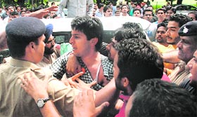 The police rescues a PUSU supporter who was bashed up by an activist of the rival party.