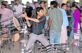 A student throws a chair at his opponent on the Panjab University campus on Friday.