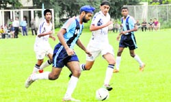 Players vie for the ball during a match at the RIMC Soccer Cup in Dehradun on Friday.