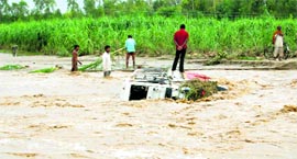 Villagers rescue passengers from the bus that overturned in the Rau river at Sarai village on Friday.