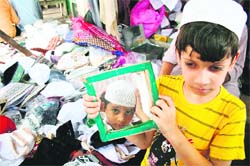 Two boys buy caps before offering namaaz on the last Friday of Ramzan