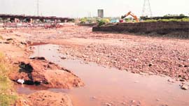 A JCB machine engaged in extracting sand from the Balol rivulet.