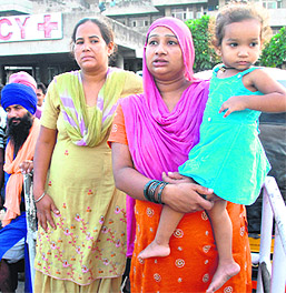 Amarjeet Kaur, wife of the deceased, holds her two-year-old daughter outside the GMCH emergency on Saturday. 