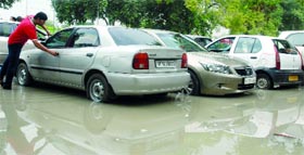 Vehicles on a waterlogged parking area in Connaught Place in New Delhi on Saturday.