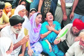 Family members and relatives of the deceased cab driver wail at Bikram Chowk in Jammu on Saturday.