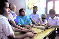 Visually impaired students read Brail with their teacher in Ludhiana on Saturday