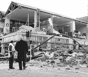 People stand outside a building damaged by a massive earthquake in central Christchurch, New Zealand, on Saturday.