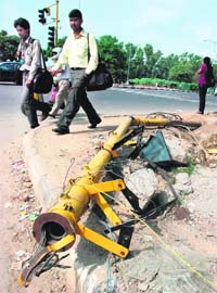 A damaged traffic light pole lying on the housing board traffic lights point in Chandigarh