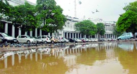 Commuters drive through a waterlogged street near Rajghat.