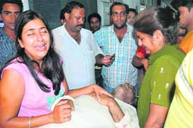 The wife and the daughter wail beside the body of Rajendra Singh at the District Hospital in Haridwar
