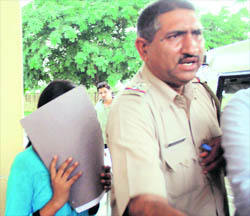 The girl who accused Gopal Kandas former driver and his accomplices of raping her being taken to a police station in Gurgaon.