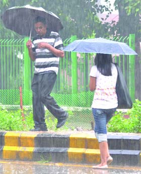 Pedestrians cuaght in a sudden downpour in New Delhi