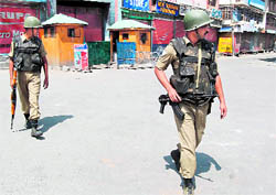 Securitymen patrol a deserted street in Srinagar following the imposition of the curfew in parts of the city on Tuesday