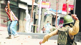 A Kashmiri protester throws stones at security personnel in Srinagar.