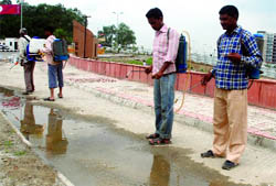Workers spray the chemical outside the Games Village in New Delhi on Wednesday