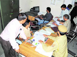 Police personnel scrutinise records at the education boards office in Dharamsala on Wednesday