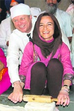 Mike Rann, Premier of South Australia, and his wife Sasha Carrouzza make a chapati for langar in the Golden Temple complex on Friday.
