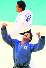 South Koreas Kim Jae-bum (blue) celebrates his win over Brazils Leandro Guilheiro at the World Judo CHampionship in Tokyo