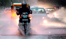Heavy rain reduces visibility, forcing vehicle drivers to switch on headlights on the road separating Sectors 27 and 30, Chandigarh, on Saturday.