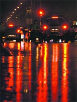 Tail lamps of vehicles reflect a colourful pattern on a road near Sector 20.