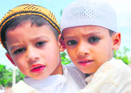 Two boys in traditional attire greet each other at the Jama Masjid Eidgah in Jwalapur, Haridwar