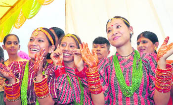 Nepali girls, with their hands embellished with henna and bangles, enjoy themselves during Hartalika Teej in Dehradun