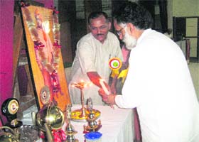 MP Rajan Sushant lights the ceremonial lamp during the the Universal Brotherhood Day function at Kangra