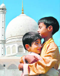 Two boys hug each other after offering Eid prayers at Hazratbal in Srinagar on Saturday.