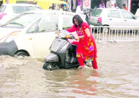 A woman pulls her scooter after it broke down