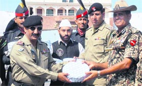 BSF Commandant Sumer Singh receives a box of sweets from Saleem Sher Jung, Commander, Pakistan Rangers, on the occasion of Eid-ul-Fitr on the Wagah-Attari border.