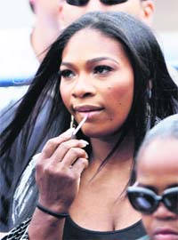 FANCY TOUCH: Serena Williams puts on lipstick during the match between Venus Williams of the US and Kim Clijsters of Belgium at the US Open tennis tournament in New York