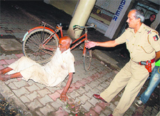 An old man lies on a footpath.