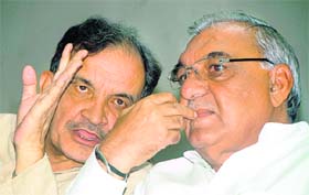 Chief Minister Bhupinder Singh Hooda and MP Birender Singh discuss a point at a meeting of the Congress in Chandigarh