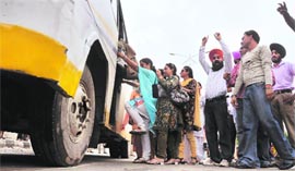 ETT teachers board a bus to protest in Amritsar.