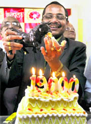 A broker offers a piece of cake to a replica of a 'Bull' to celebrate the BSE Sensex crossing 19,000 points, in Bhopal on Monday.