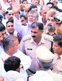 A police officer pacifies agitating Akhil Bharatiya Jat Sangharsh Samiti activists in Sonepat district