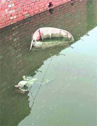 A rickshaw gets submerged in rainwater in Karnal