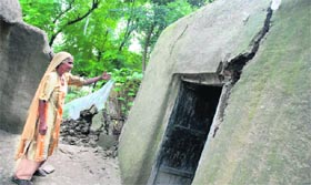 Kasturi Devi shows a damaged wall of her house at Karnals Nangli village caused by the flooded Yamuna.