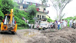 A JCB being used to clear debris following a landslide on the Toani Devi road in Hamirpur on Monday.