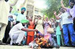 EET teachers burn an effigy of Panchayat Minister Ranjit Singh Bramhpura at the Zila Parishad office in Ludhiana on Monday.