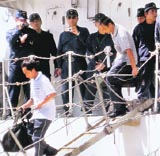 Crew members of a Chinese fishing boat disembark from a Japan Coast Guard patrol vessel at Ishigaki port on Monday.