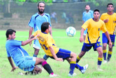 A footballer from BAM Khalsa College, Garhshankar, tries to clear the ball from the danger area during a match against the PU Campus team in the PU Inter-College Football Championship held in Chandigarh on Monday. 