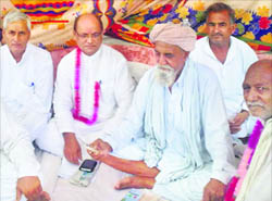 Samast Bhartiya Party chief Sudershan Agarwal sit on a dharna with Gorakhpur farmers in Fatehabad on Tuesday.