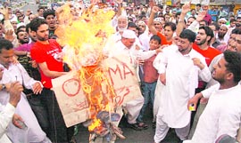 Protesters burn an effigy of US President Barak Obama at Malik Market in Jammu on Tuesday.