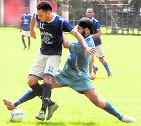 A player tries to catch hold of the ball during a football match at Panjab University